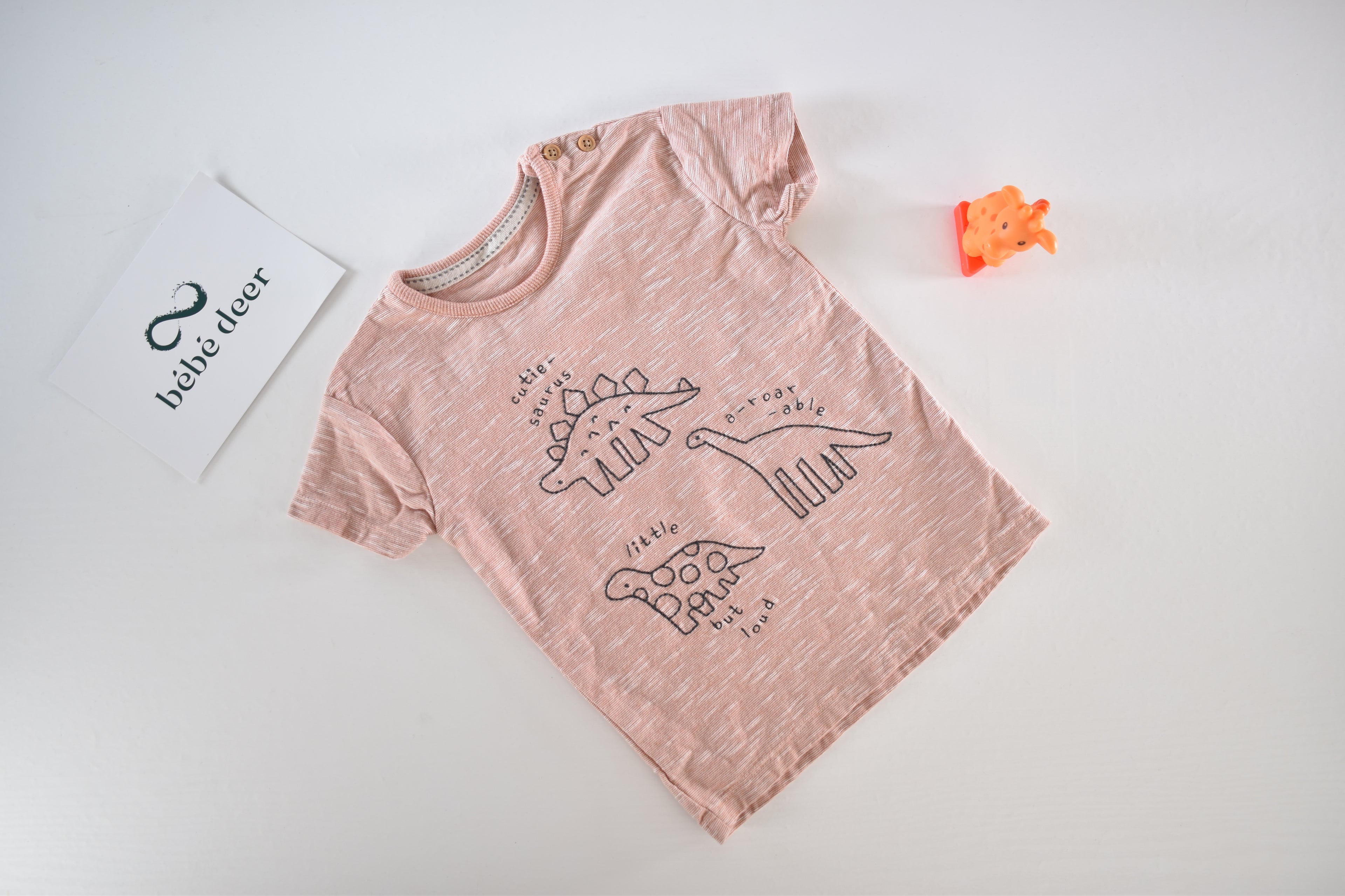 Pale pink short-sleeve top with dinosaur