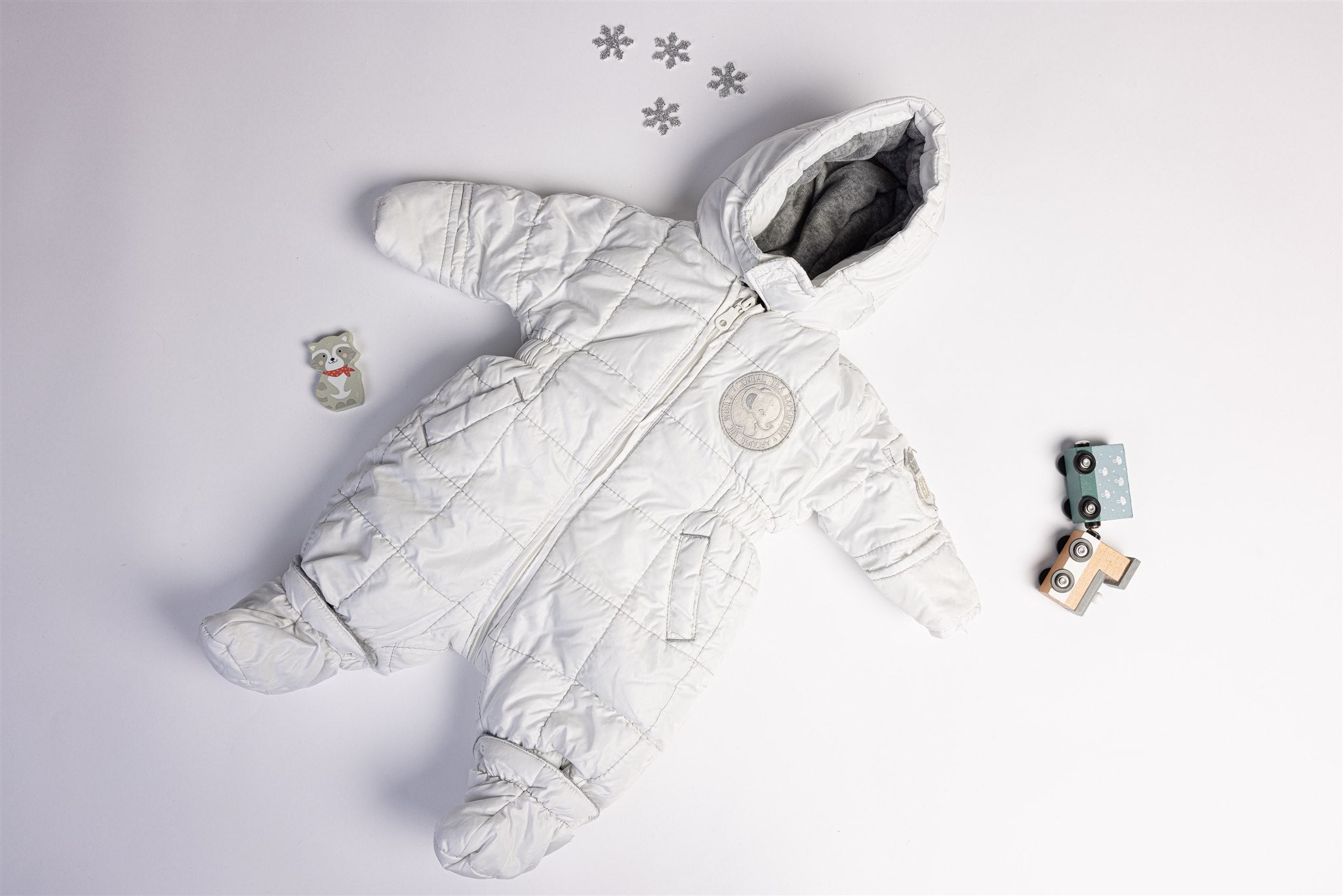 White quilted pramsuit with elephant badge
