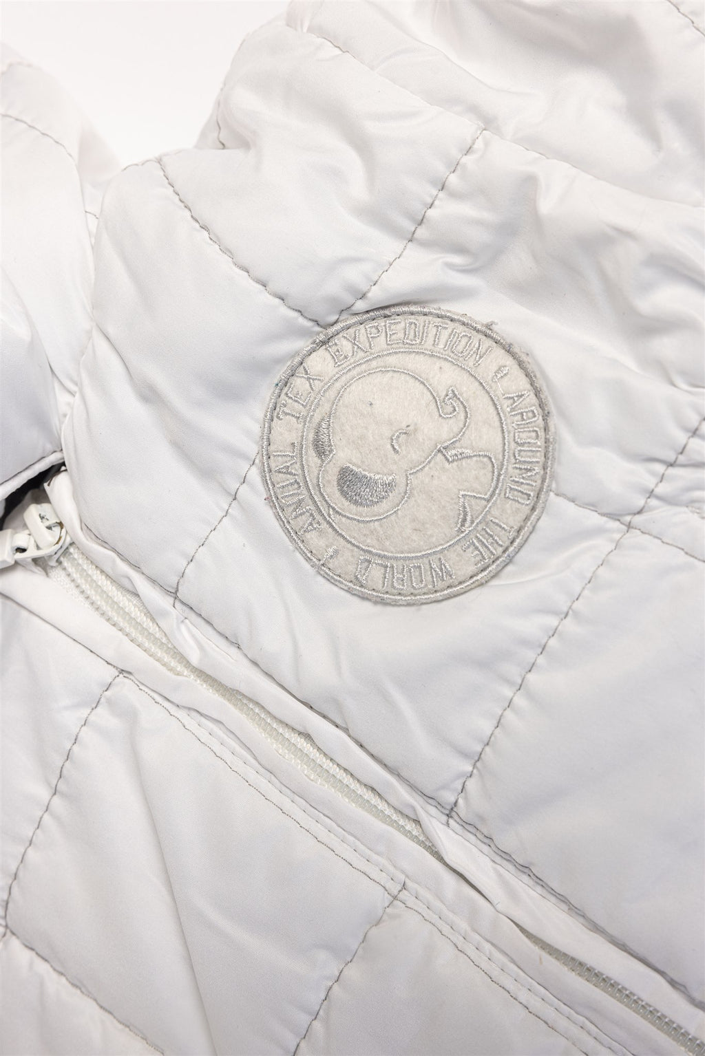 White quilted pramsuit with elephant badge