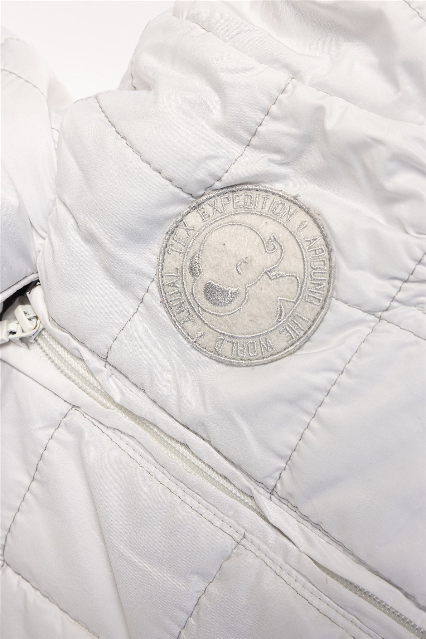White quilted pramsuit with elephant badge