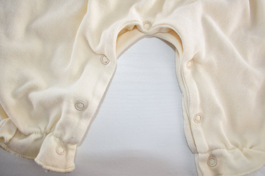 Cream sleepsuit featuring lace ruffle details