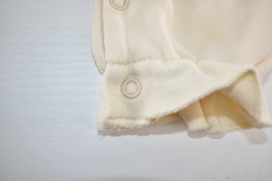 Cream sleepsuit featuring lace ruffle details