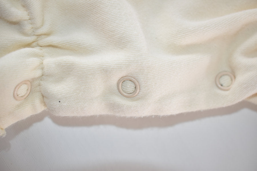 Cream sleepsuit featuring lace ruffle details