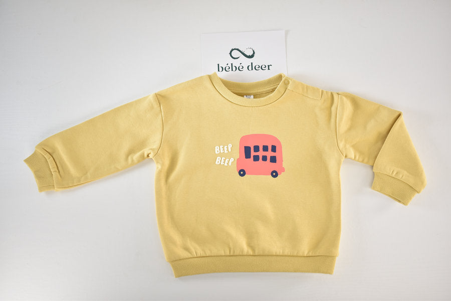 Pull jaune avec un imprimé de bus et l'inscription « Beep Beep »