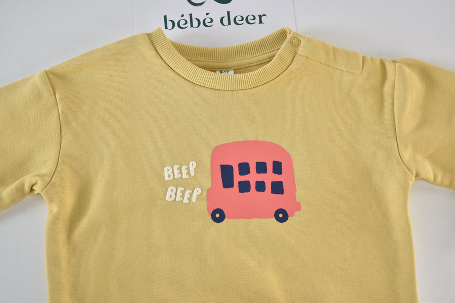 Pull jaune avec un imprimé de bus et l'inscription « Beep Beep »