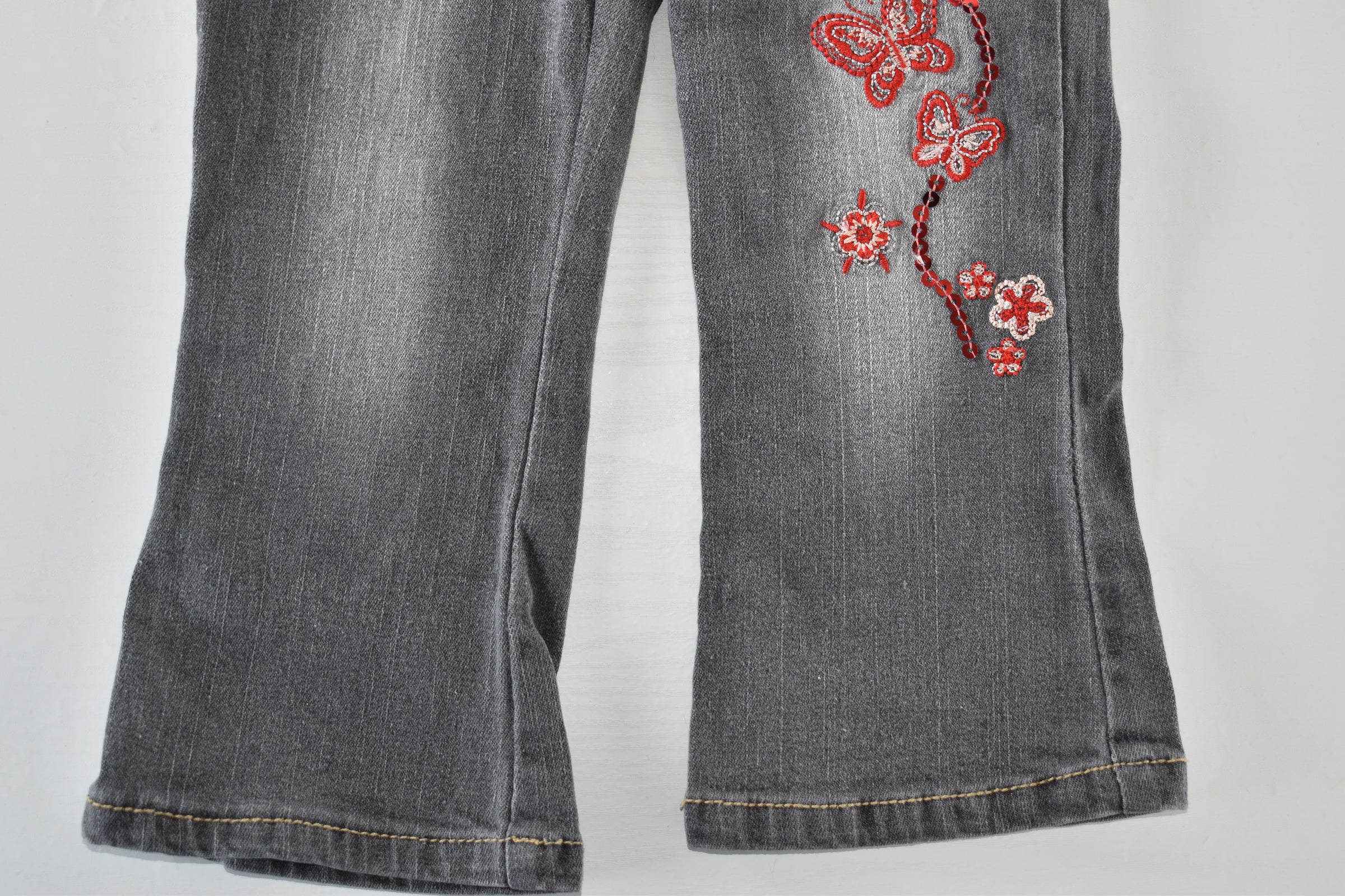 Butterfly embroidered jeans with red belt