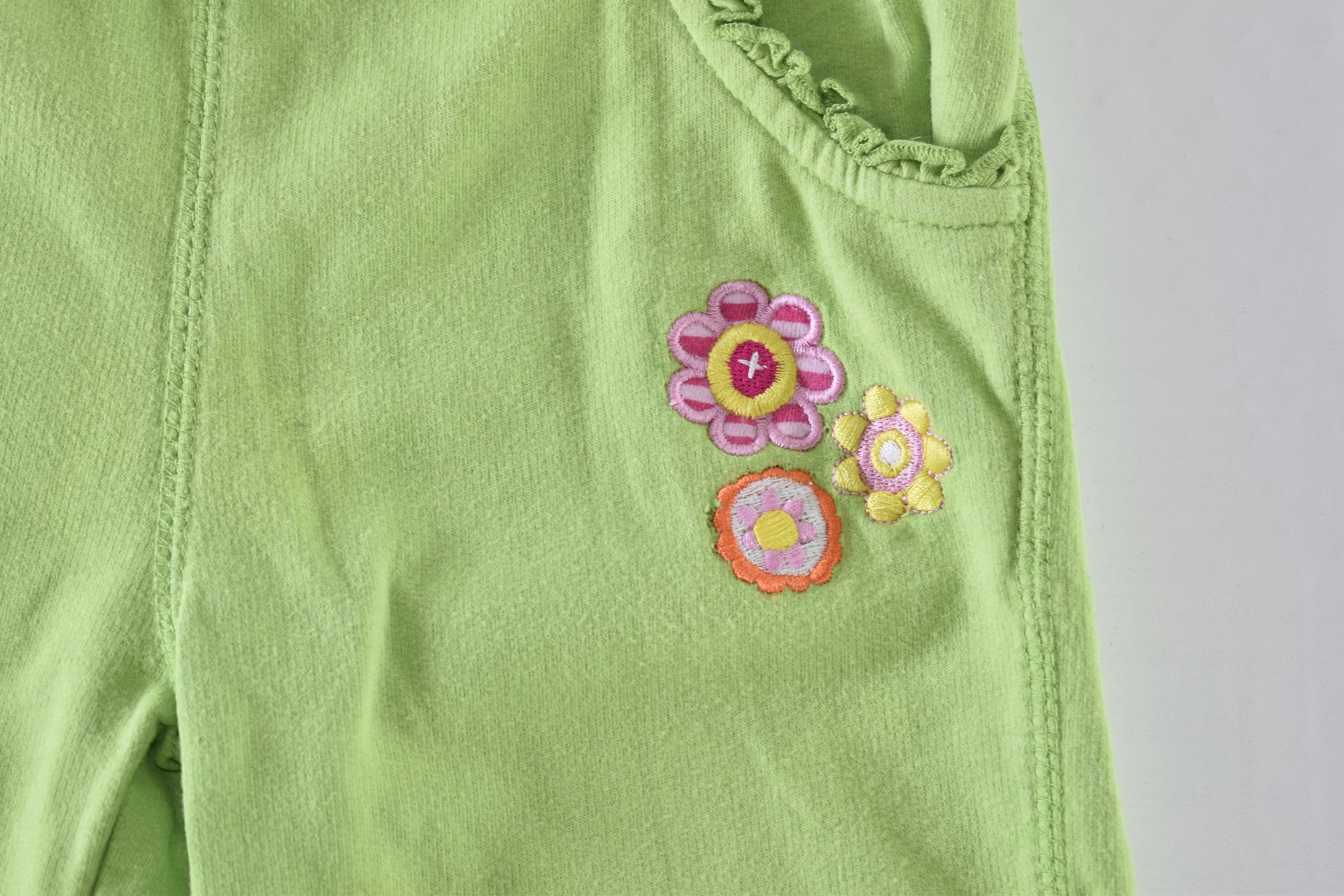 Green trousers with embroidered flowers