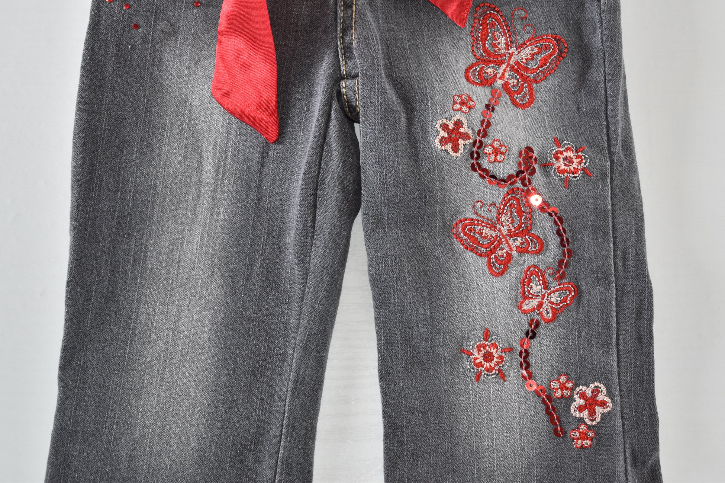 Butterfly embroidered jeans with red belt