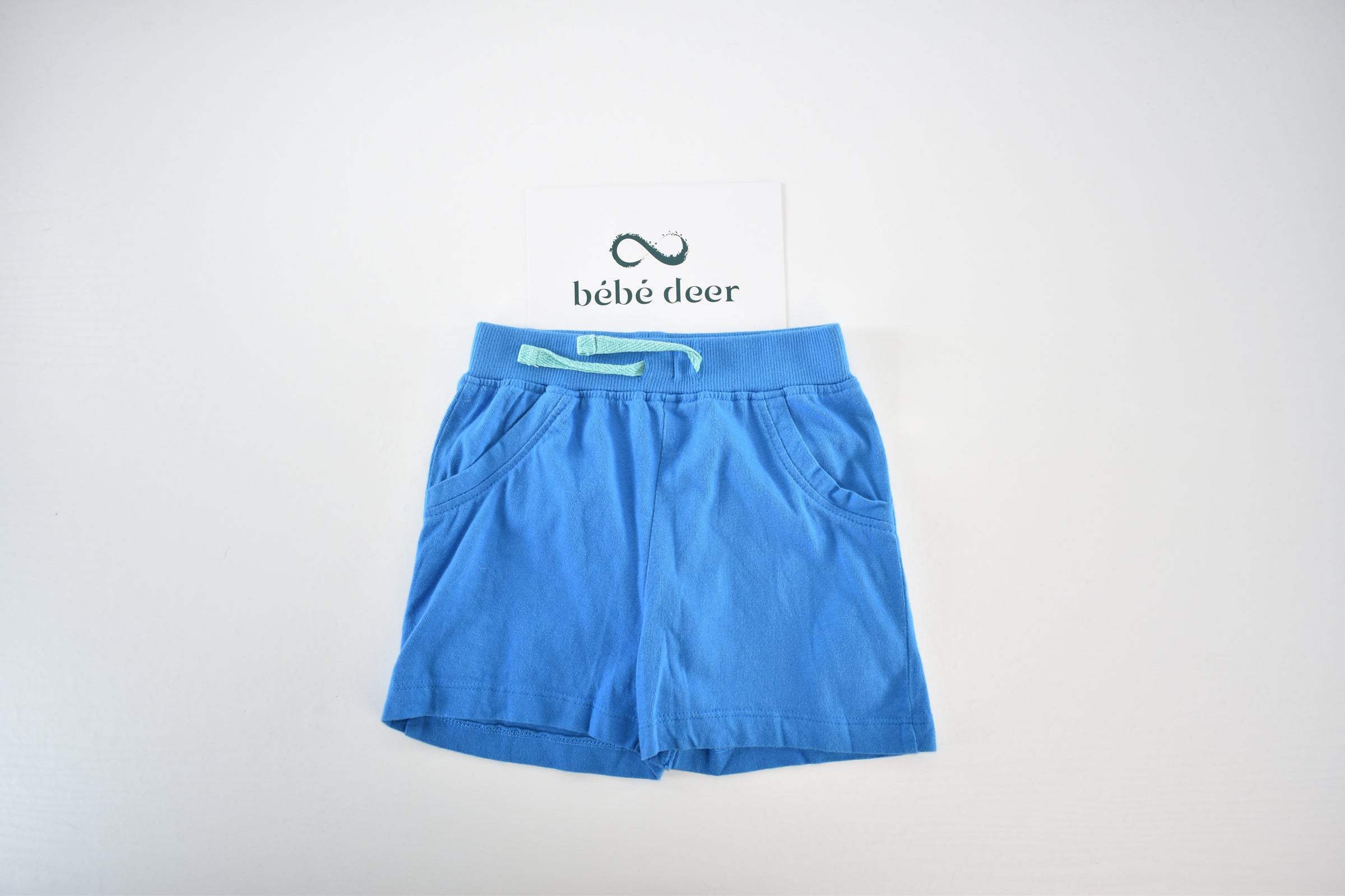 Bright blue jersey shorts with decorative pockets