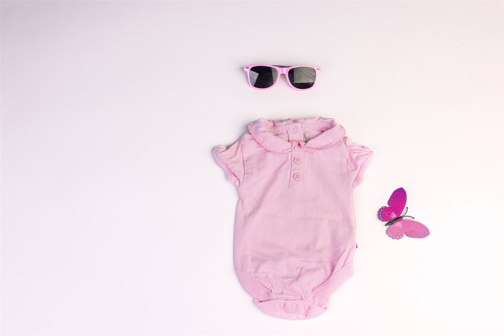 Pink short-sleeved bodysuit with a collar and two faux flower buttons
