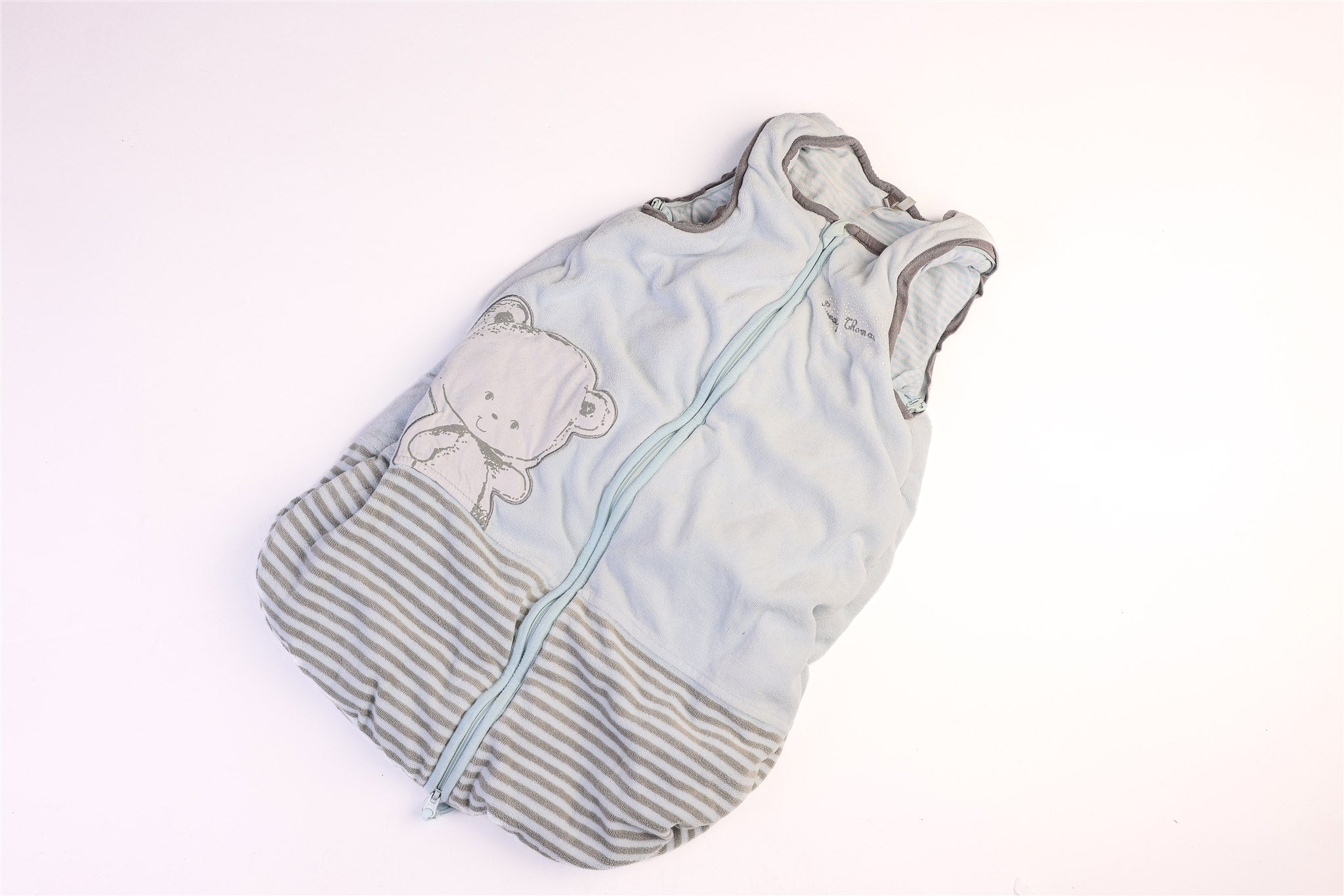Blue and striped hem sleeping bag with a small teddy bear