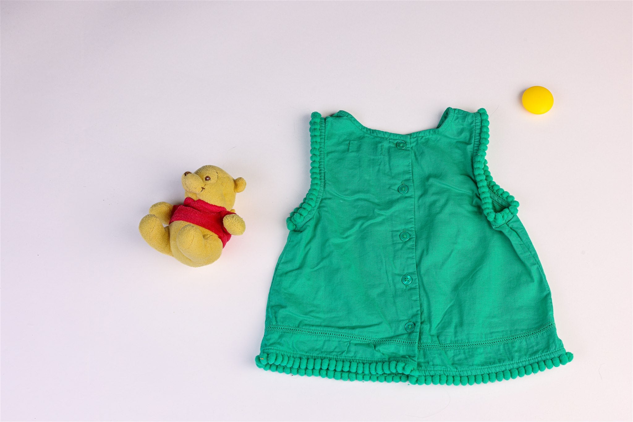 Green top with pompoms on the sleeves and hem