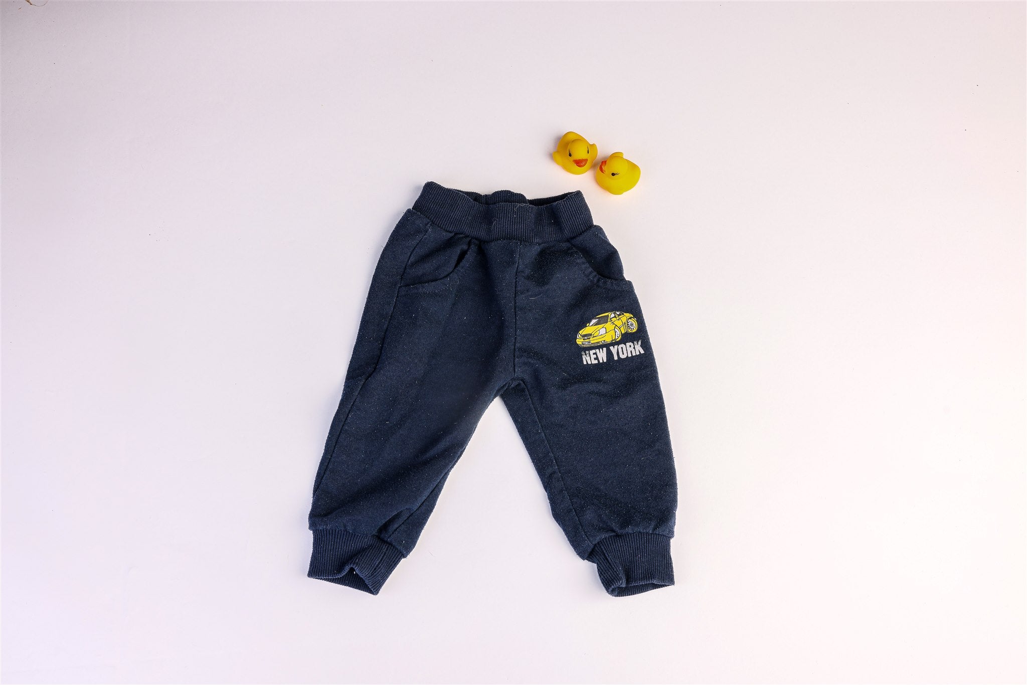 Navy blue trousers with a yellow "New York" car print