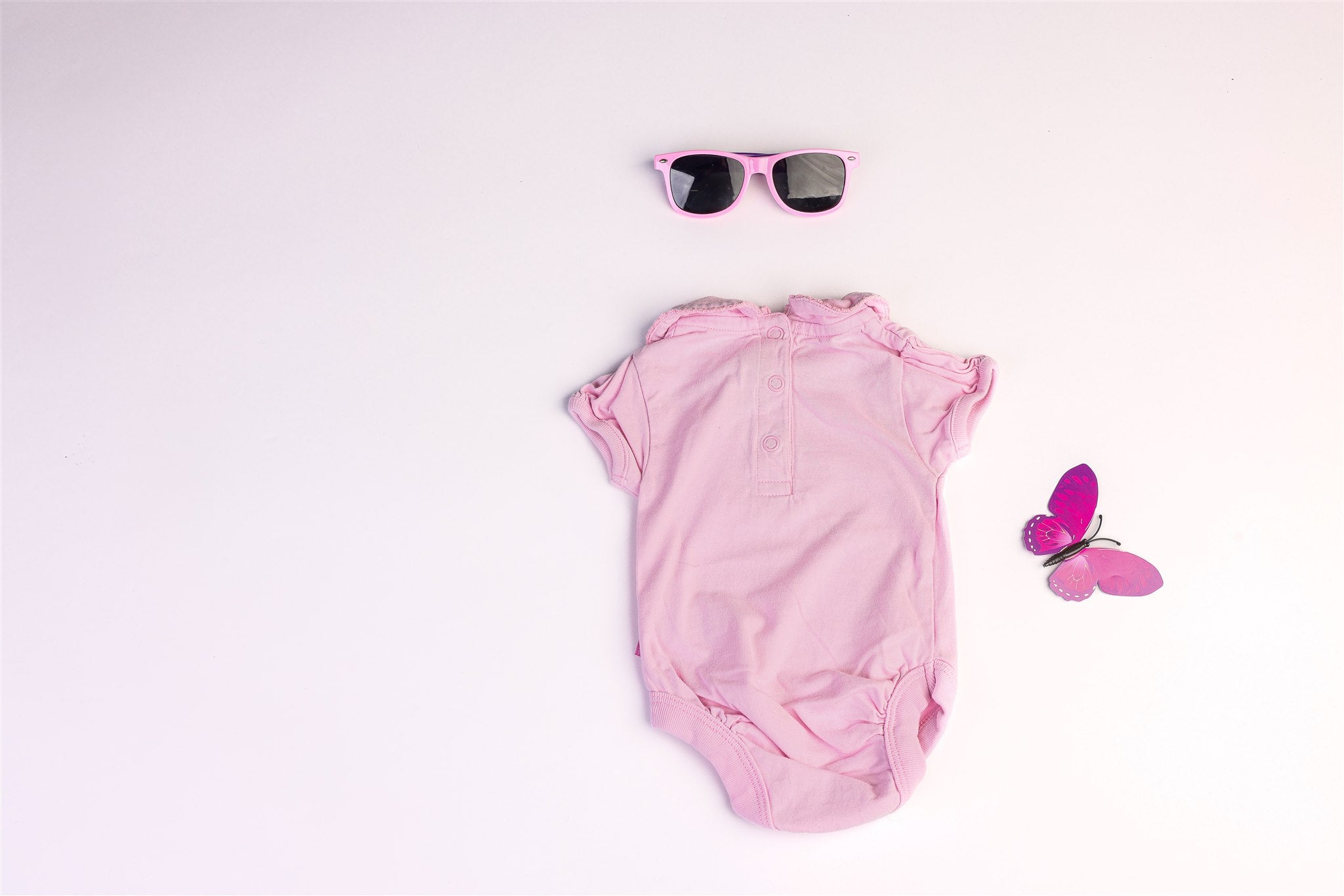 Pink short-sleeved bodysuit with a collar and two faux flower buttons